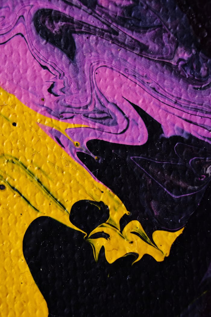 Dynamic abstract painting with bold yellow and purple swirls on a textured canvas.